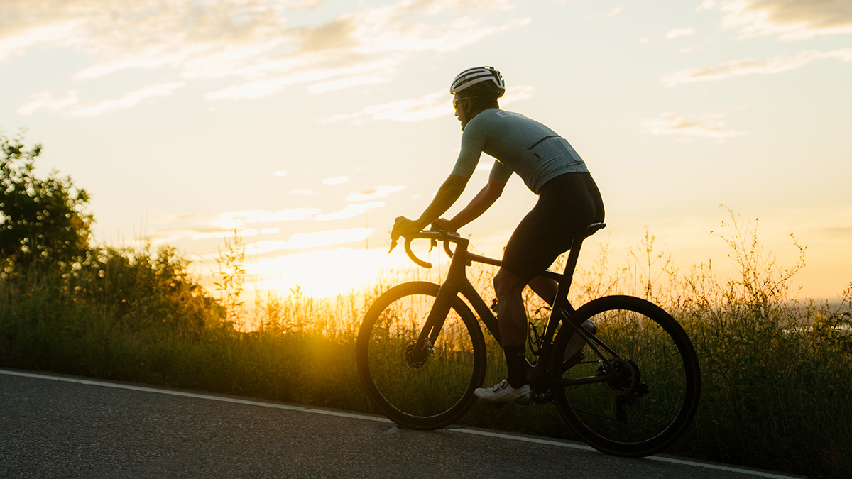 Runner Doing Cycling Workout Up A Hill With Sunset In Background