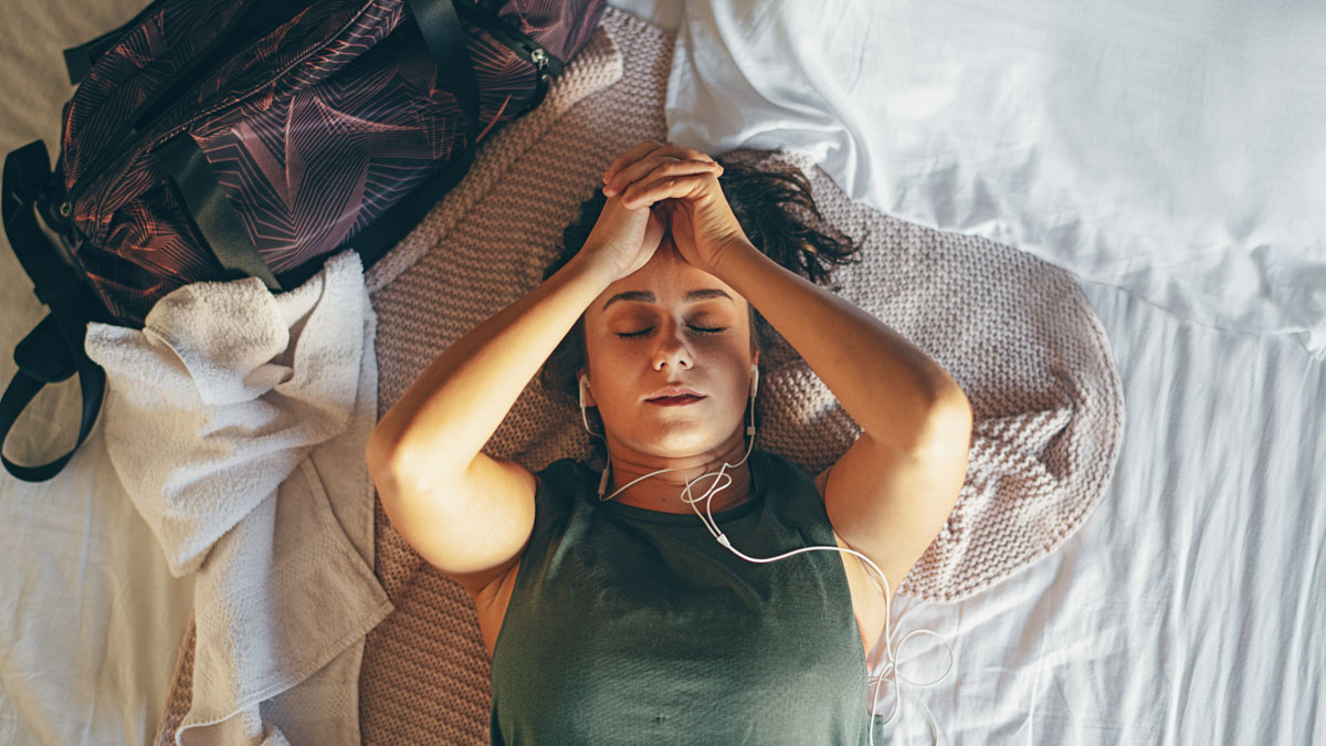Young Woman After Training Lying On Bed And Listening Music Young Woman After Training Lying On Bed And Listening Music