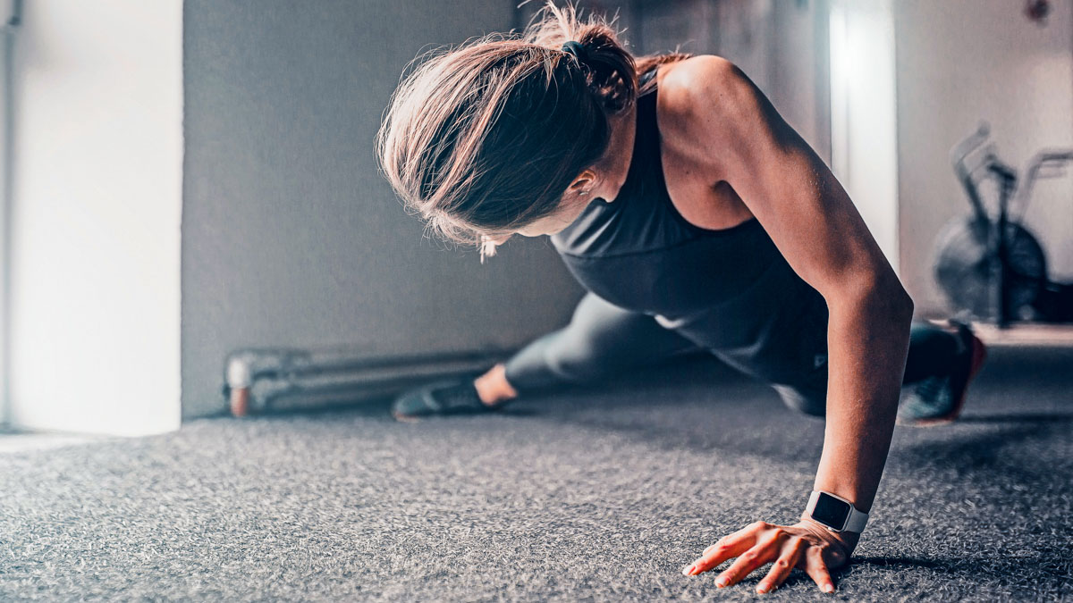 Strong Athletic Slim Woman Performs Push Ups On The Floor On One Arm Strong Athletic Slim Woman Performs Push Ups On The Floor On One Arm