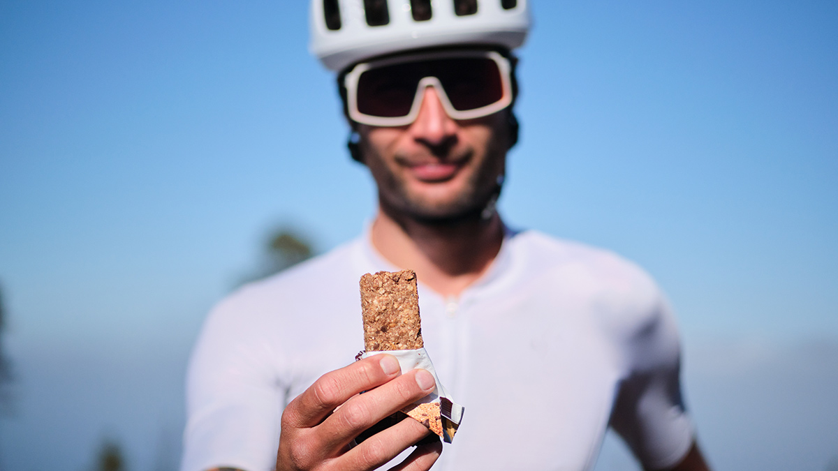 Pro Tour De France Rider Holding Up A Nutrition Bar For Recovery