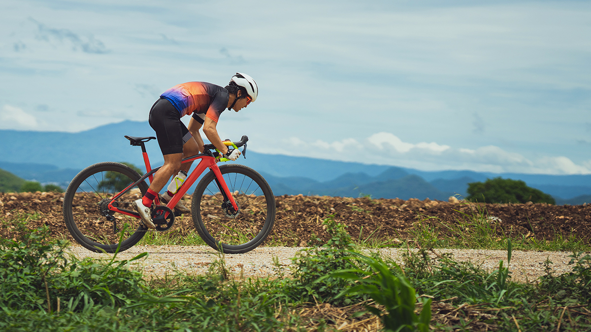 5 Most Important Things To Consider For On Bike Performance A Cyclist Out Of The Saddle Riding Hard On A Gravel Road In A Tropical Area