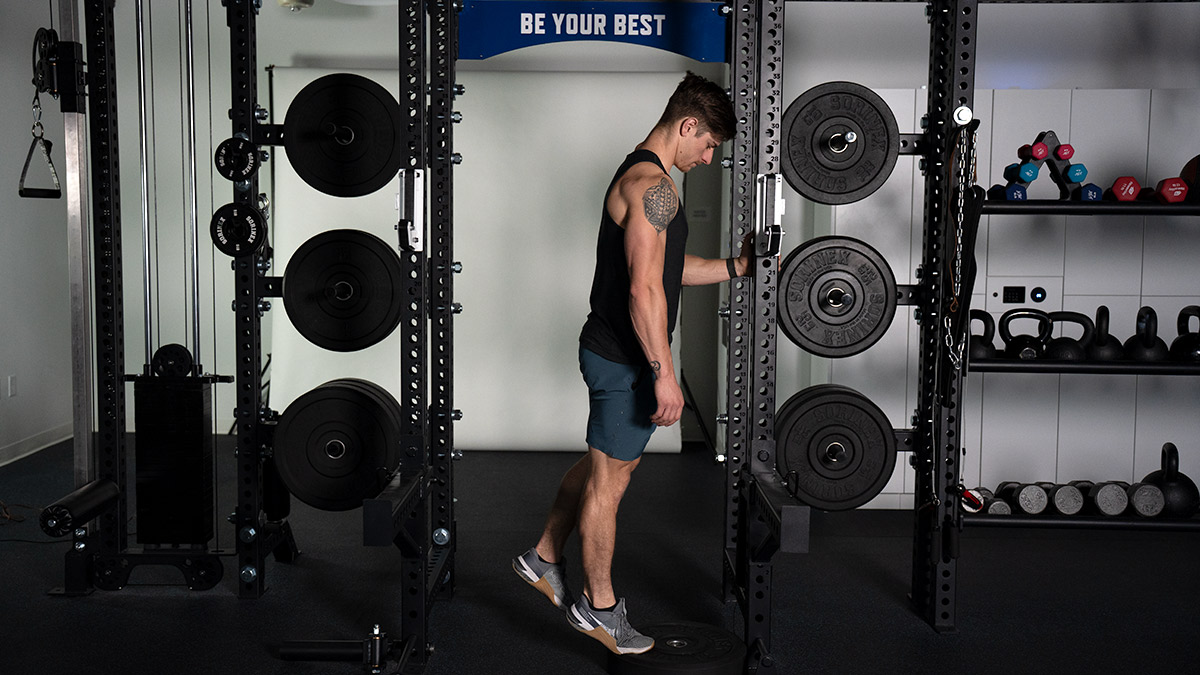 Male Runner Athlete In Gym Doing A Foot Strengthening Exercise With A Dumbbell