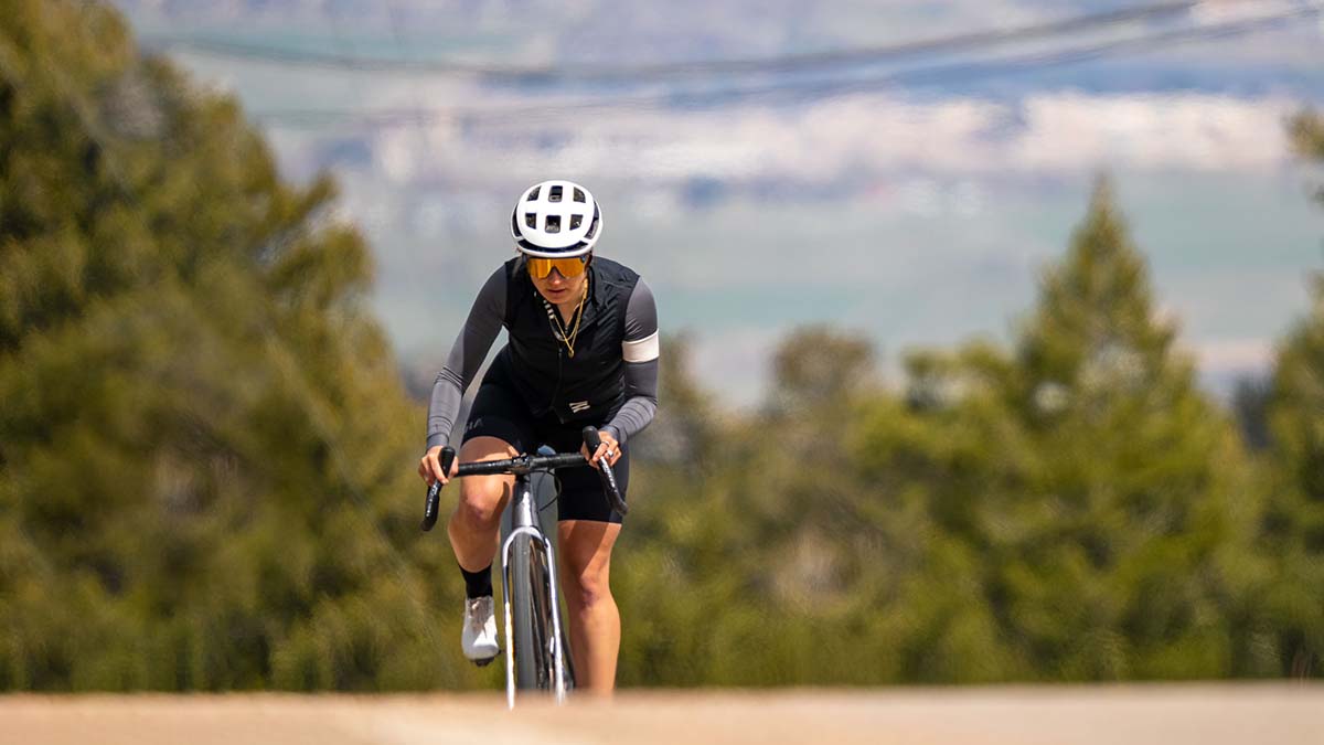 Trainingpeaks Cycling A Female Cyclist Cresting A Hill With A Vista Behind Her