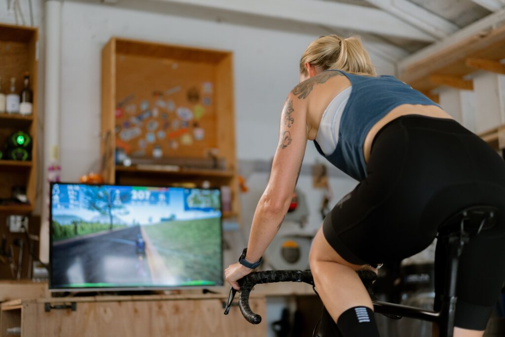 Woman riding indoor trainer using TrainingPeaks Virtual to do an FTP test and find improve her functional threshold power