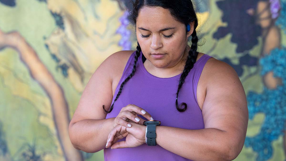 Hrv Numbers By Age A Woman Looking At Her Wearable Device Measuring Her Heart Rate For Hrv Tracking