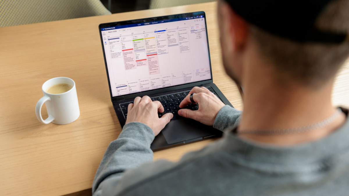 How And Why Coaches Should Sell Training Plans Trainingpeaks Coach Creating Training Plan In Trainingpeaks Store Sitting At Desk On Laptop